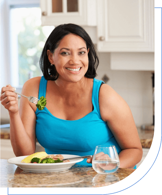 A woman sitting at the table eating food.